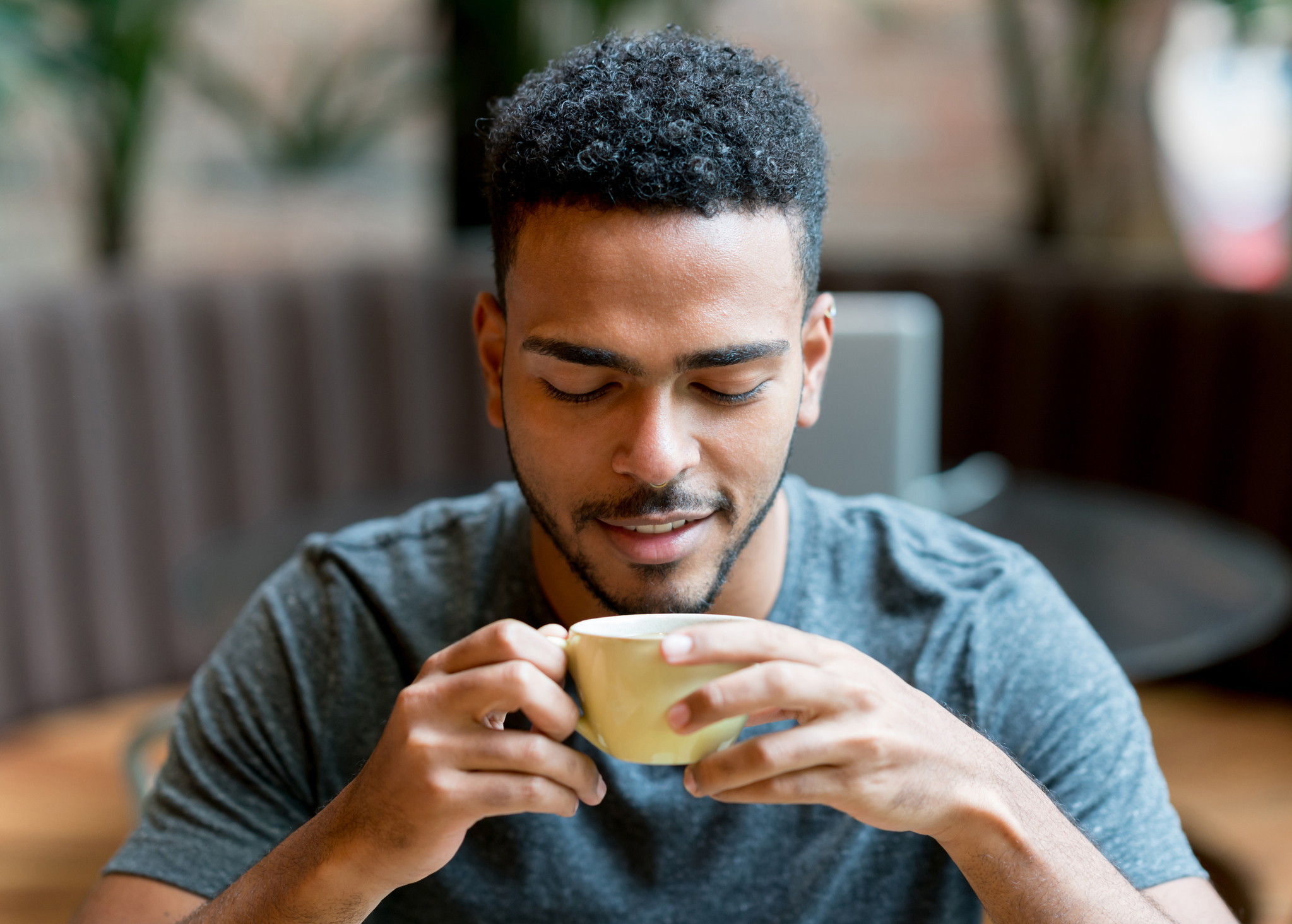 happy man drinking a cup of coffee at a cafe